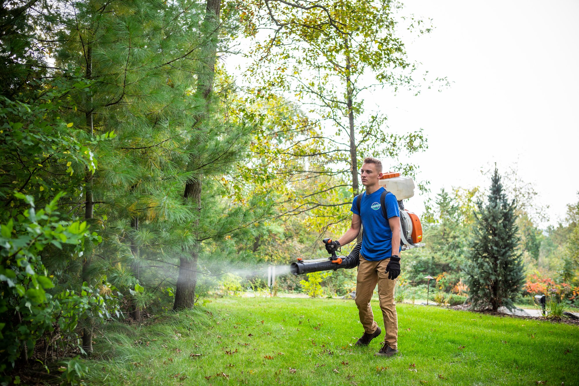 Mosquito control technician spraying residential property in Eau Claire, WI