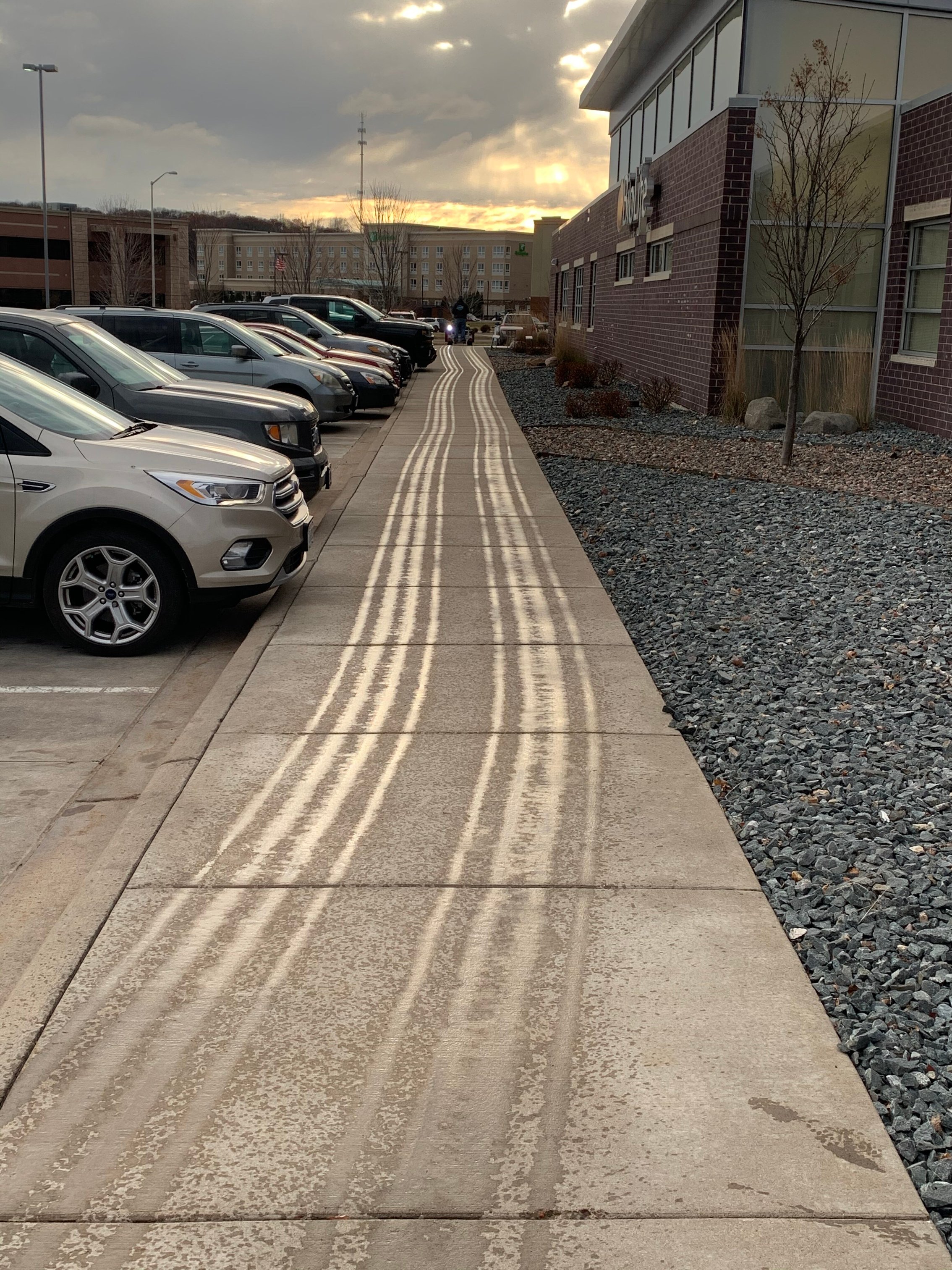 commercial snow removal company pre-treating a sidewalk with salt brine