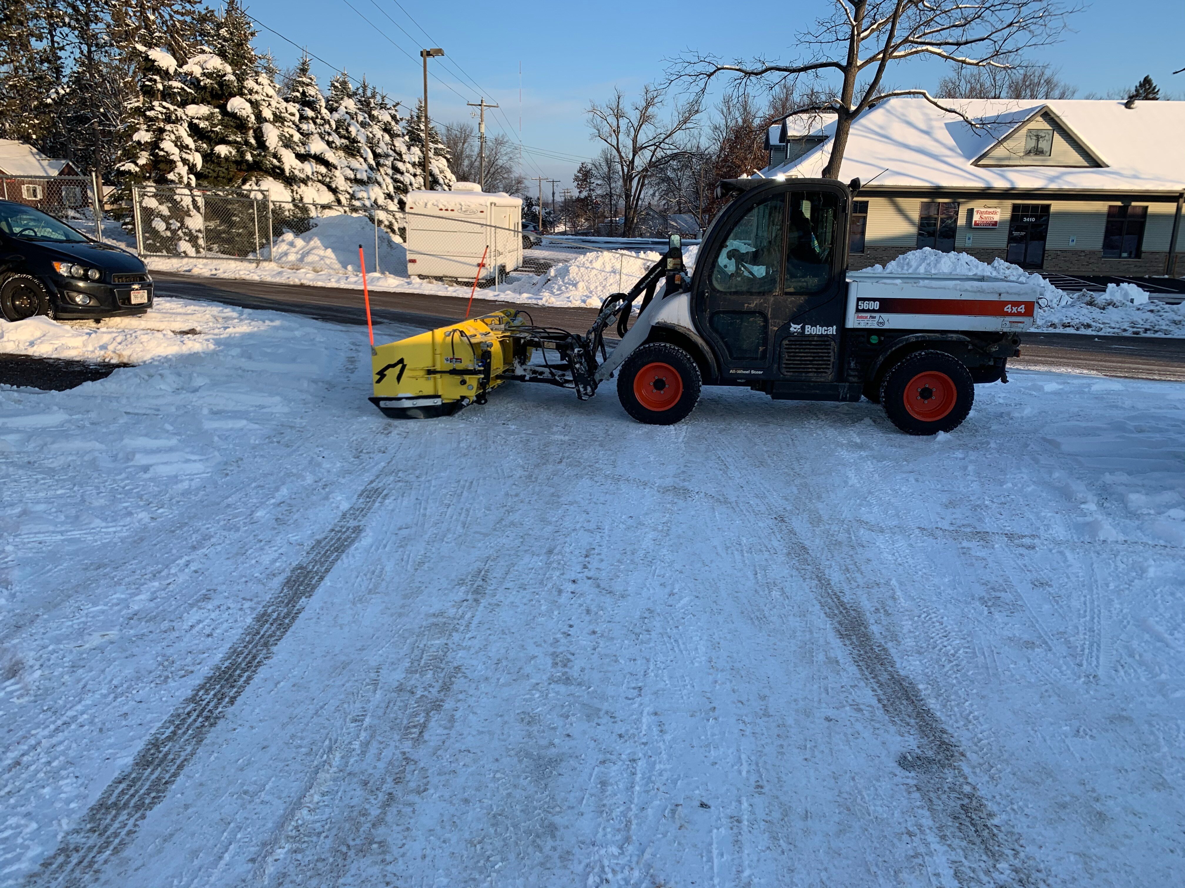 commercial snow removal machine clearing a parking lot