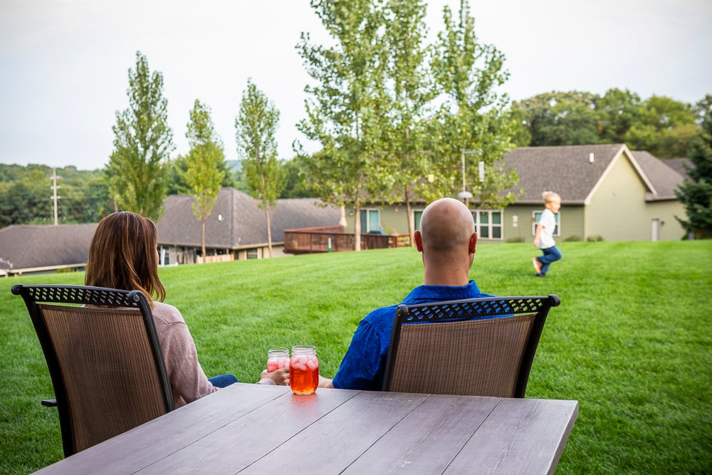 family hanging out in nice backyard with dog on nice grass