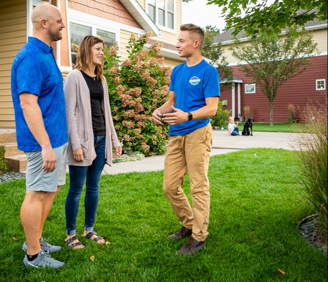 lawn care expert meets with homeowners