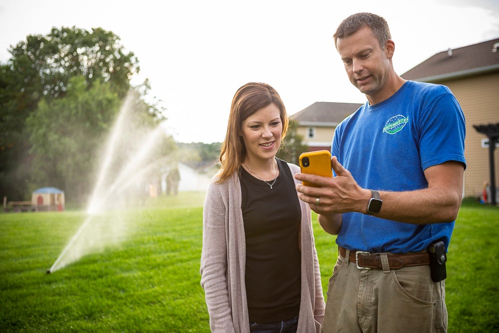 RainMaster irrigation technician and customer in lawn