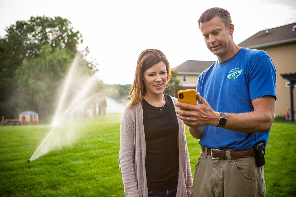 irrigation professional works with client to program sprinkler system
