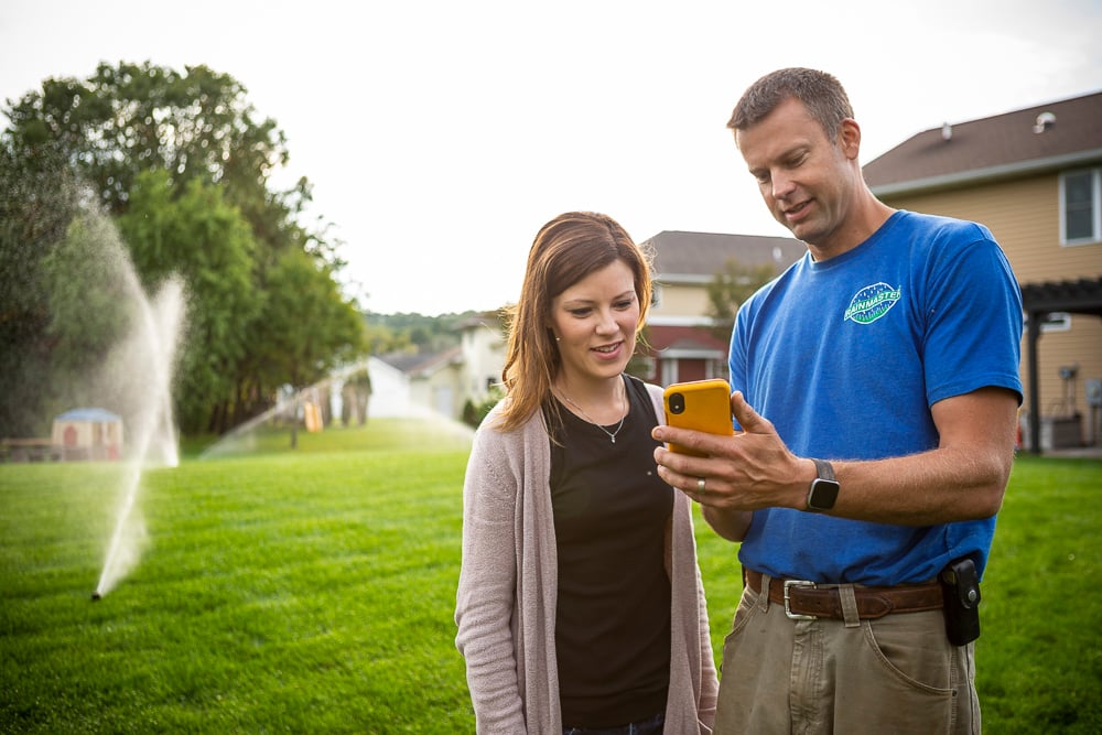 irrigation team member shows client how to use sprinkler system