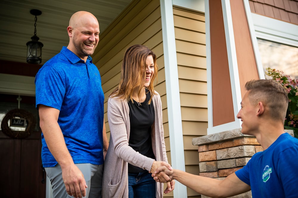 customer and lawn care technician shake hands