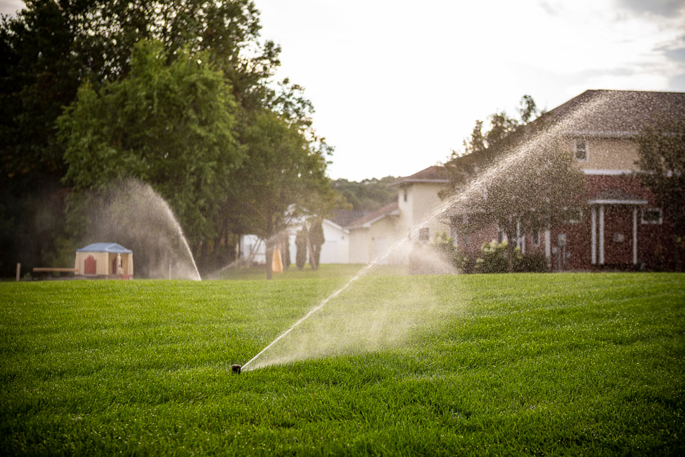 sprinkler system waters healthy lawn