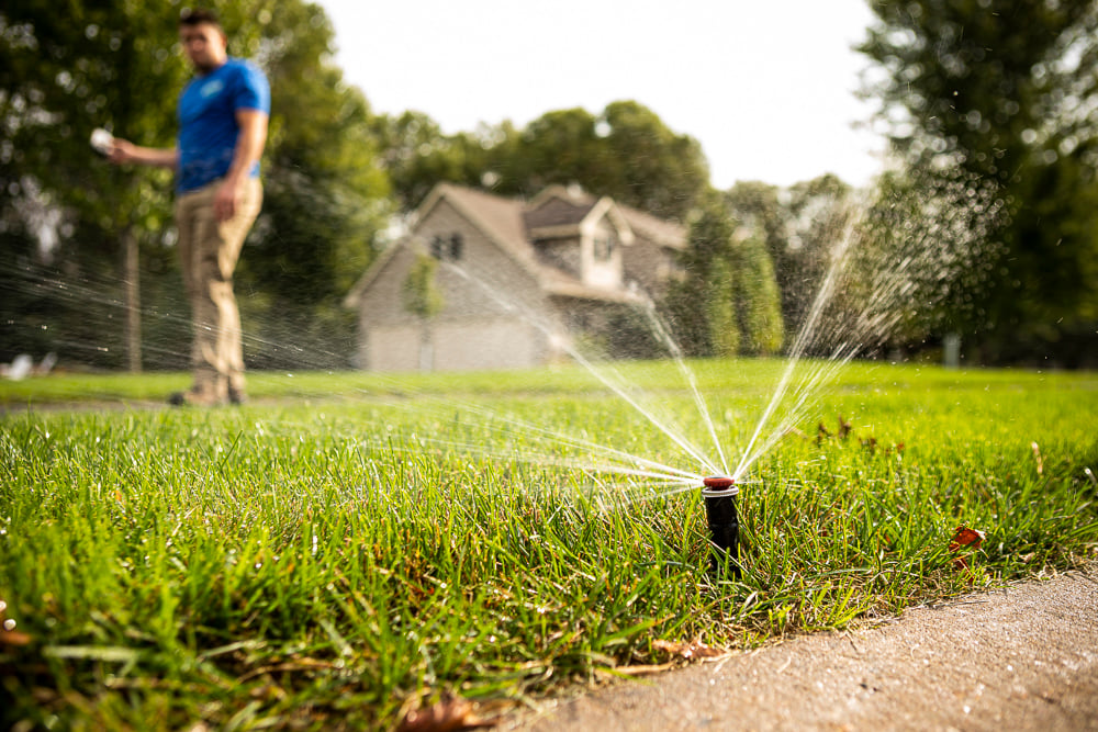irrigation technician tests sprinkler heads