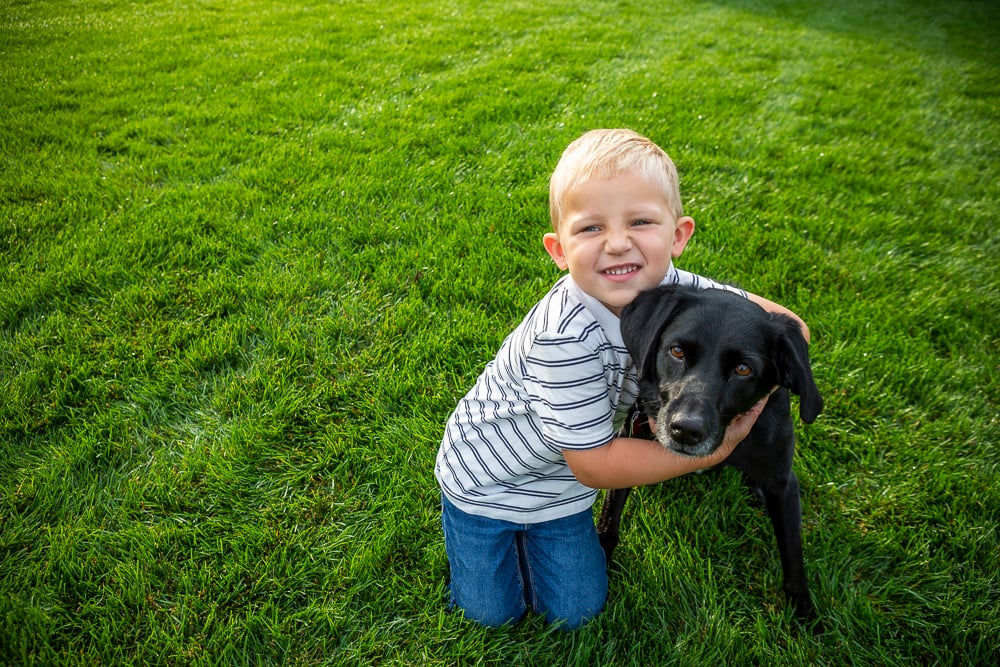 child with dog on nice green lawn