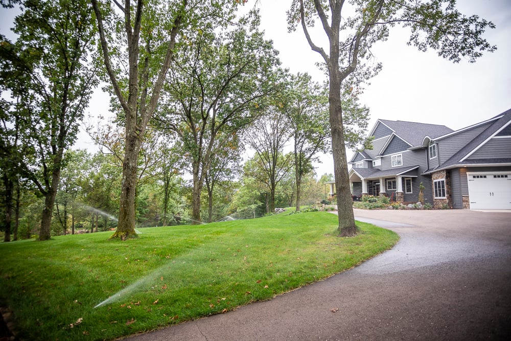 sprinklers water grass along driveway