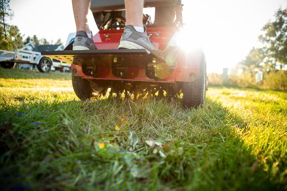 lawn care technician aerating a lawn