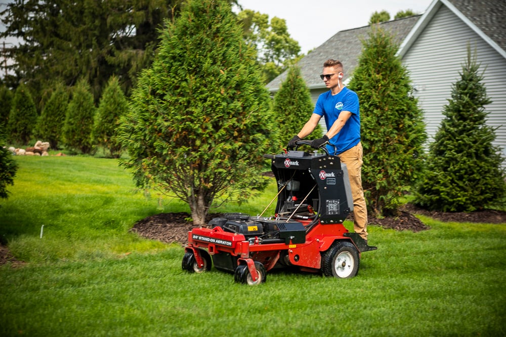 lawn care team aerates grass