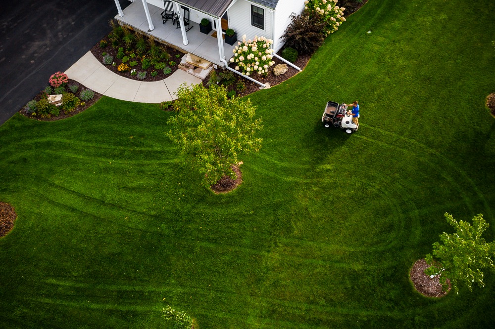 aerial photo of dark green grass being fertilized