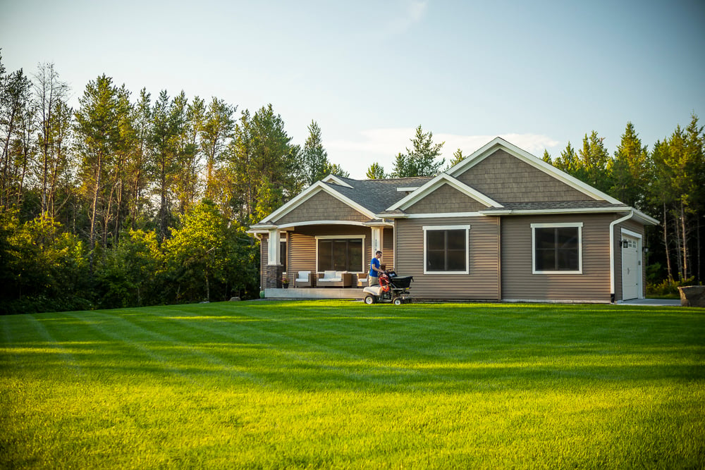 green lawn with lawn care expert fertilizing