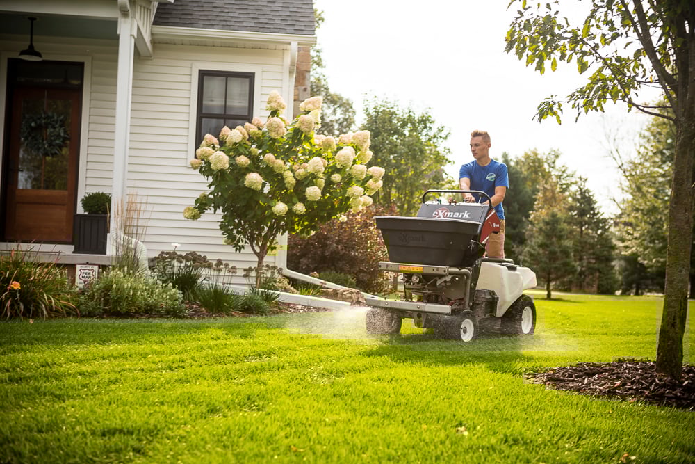 Lawn care team applying granular fertilizer