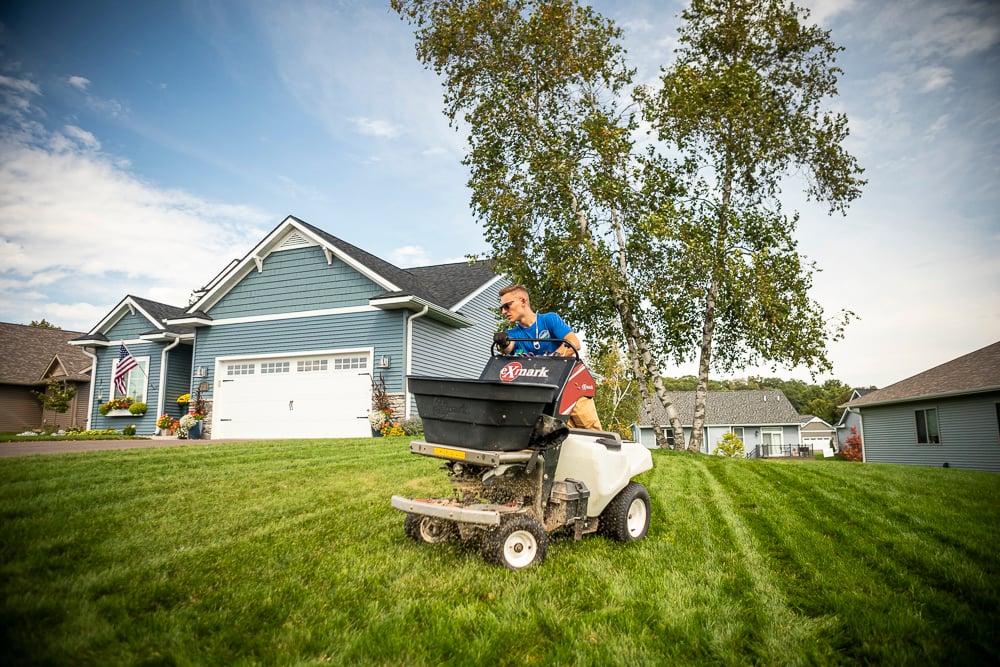 Lawn care technician in Minneapolis applying fertilizer