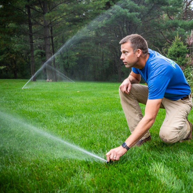 irrigation technician calibrating a lawn sprinkler system