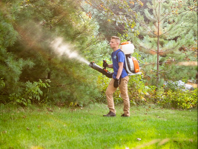mosquito control expert sprays woods for mosquitoes