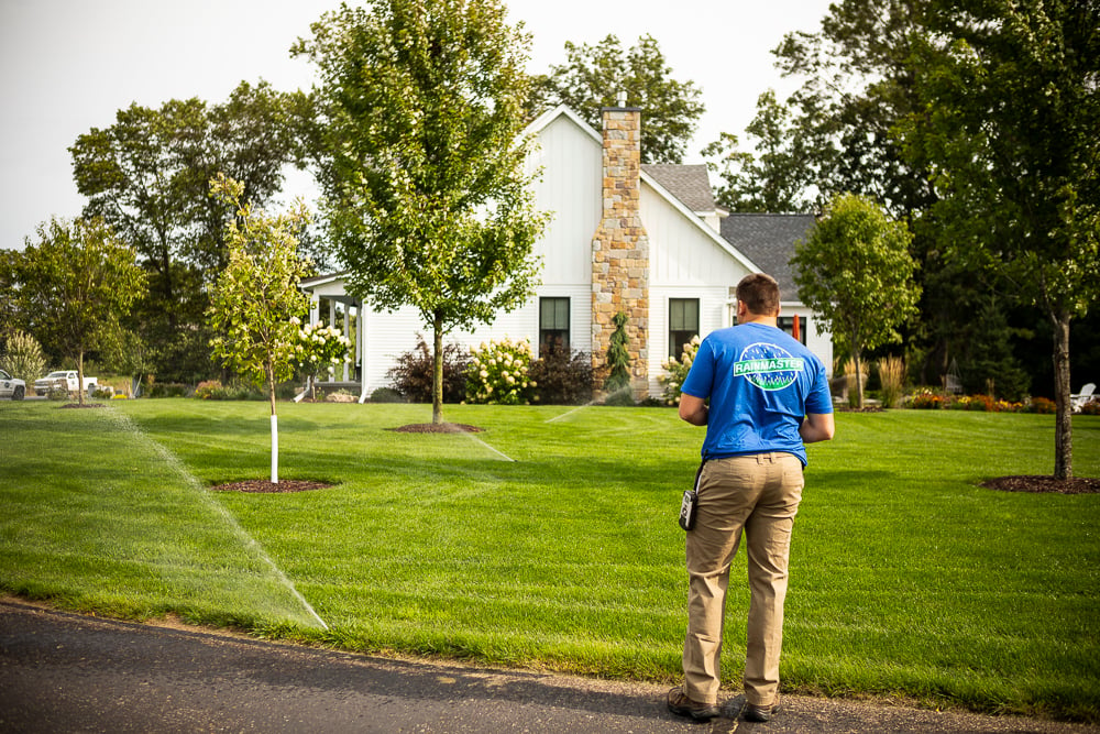 Irrigation technician adjusting sprinkler