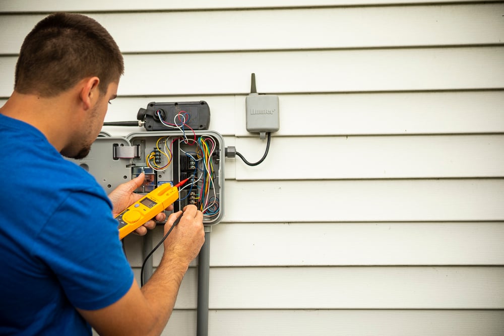 irrigation team adjusts sprinkler controller