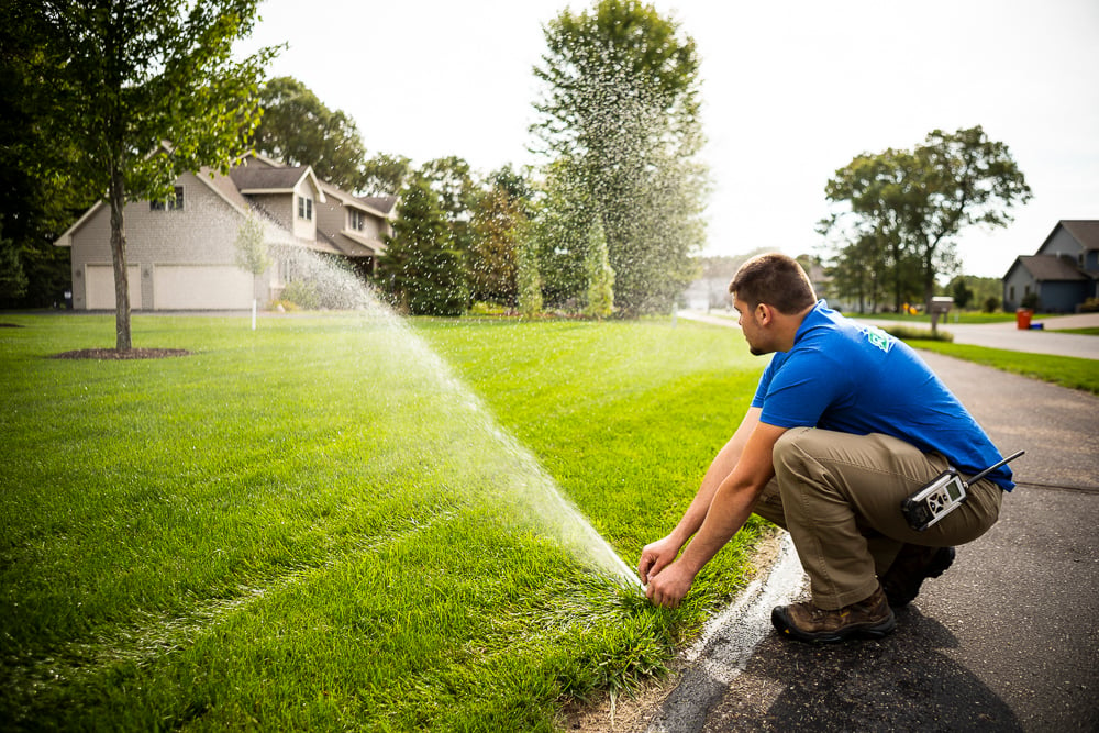 lawn irrigation technician calibrating a lawn sprinkler system