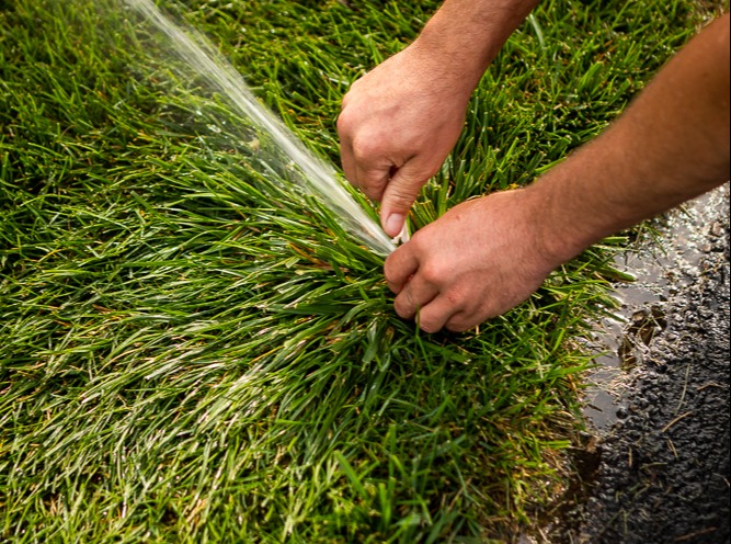 irrigation team adjusts sprinkler heads