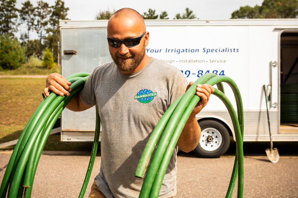 irrigation team member carries pvc pipe