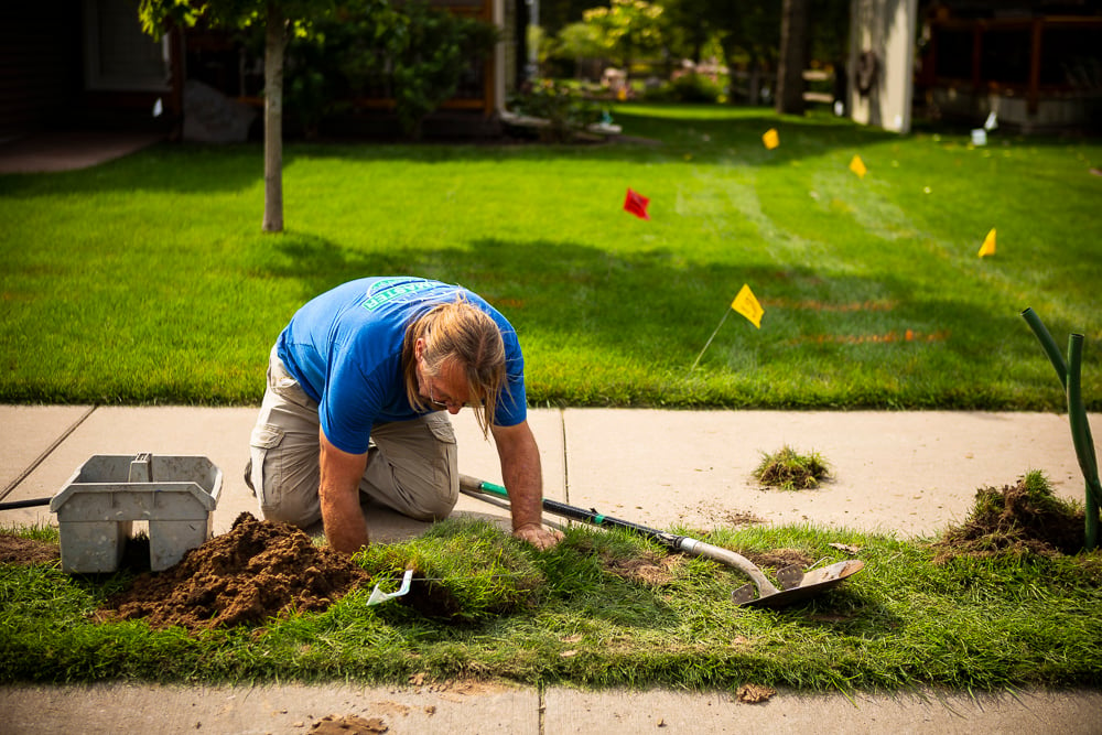 Irrigation team fixing a broken sprinkler head