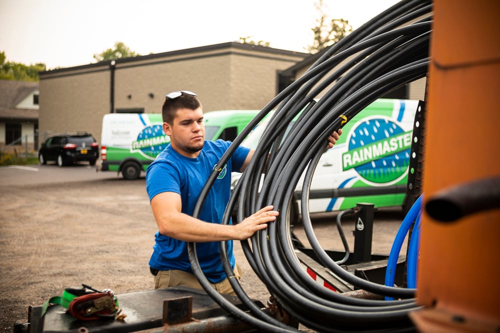 irrigation installation technician loading irrigation lines into a truck