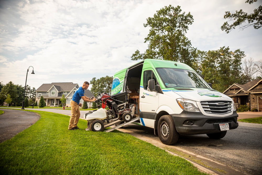 lawn care technician with equipment and van