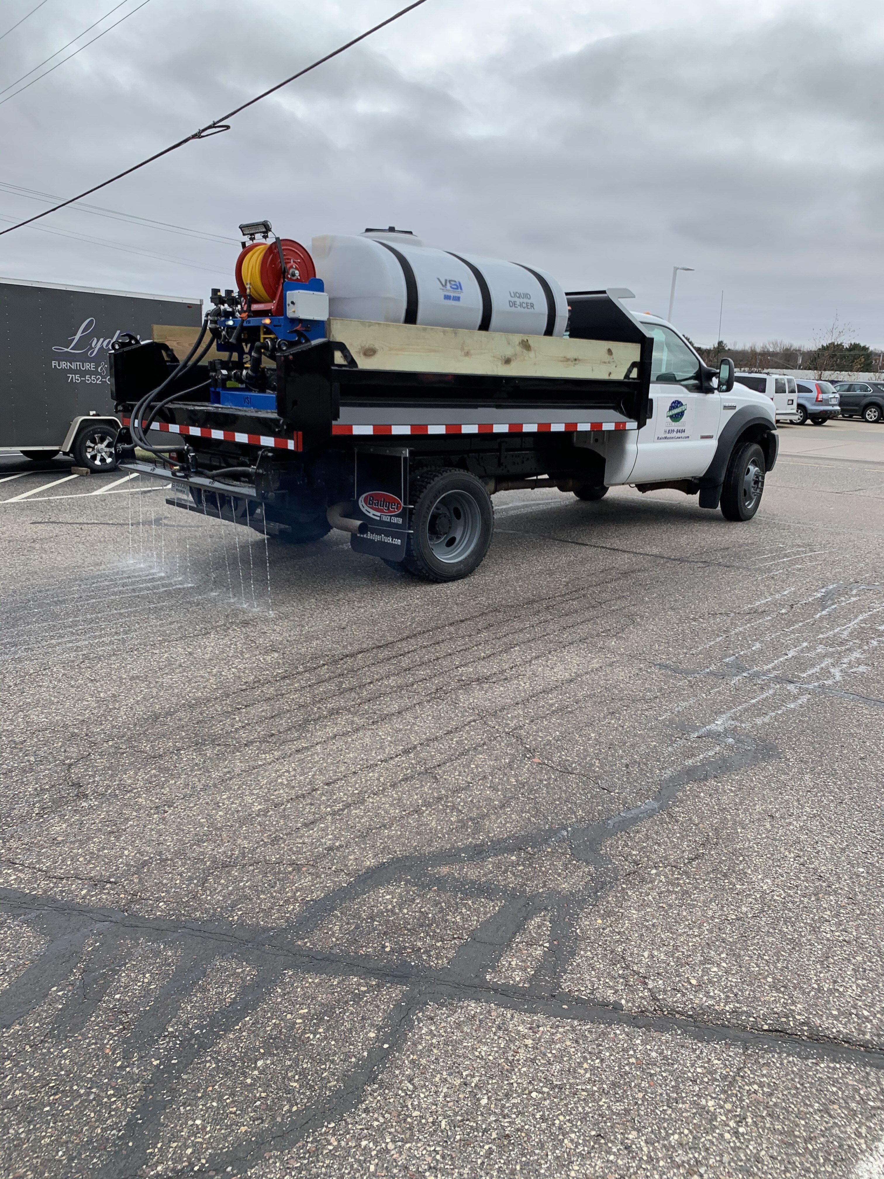snow removal truck spraying salt brine on a parking lot
