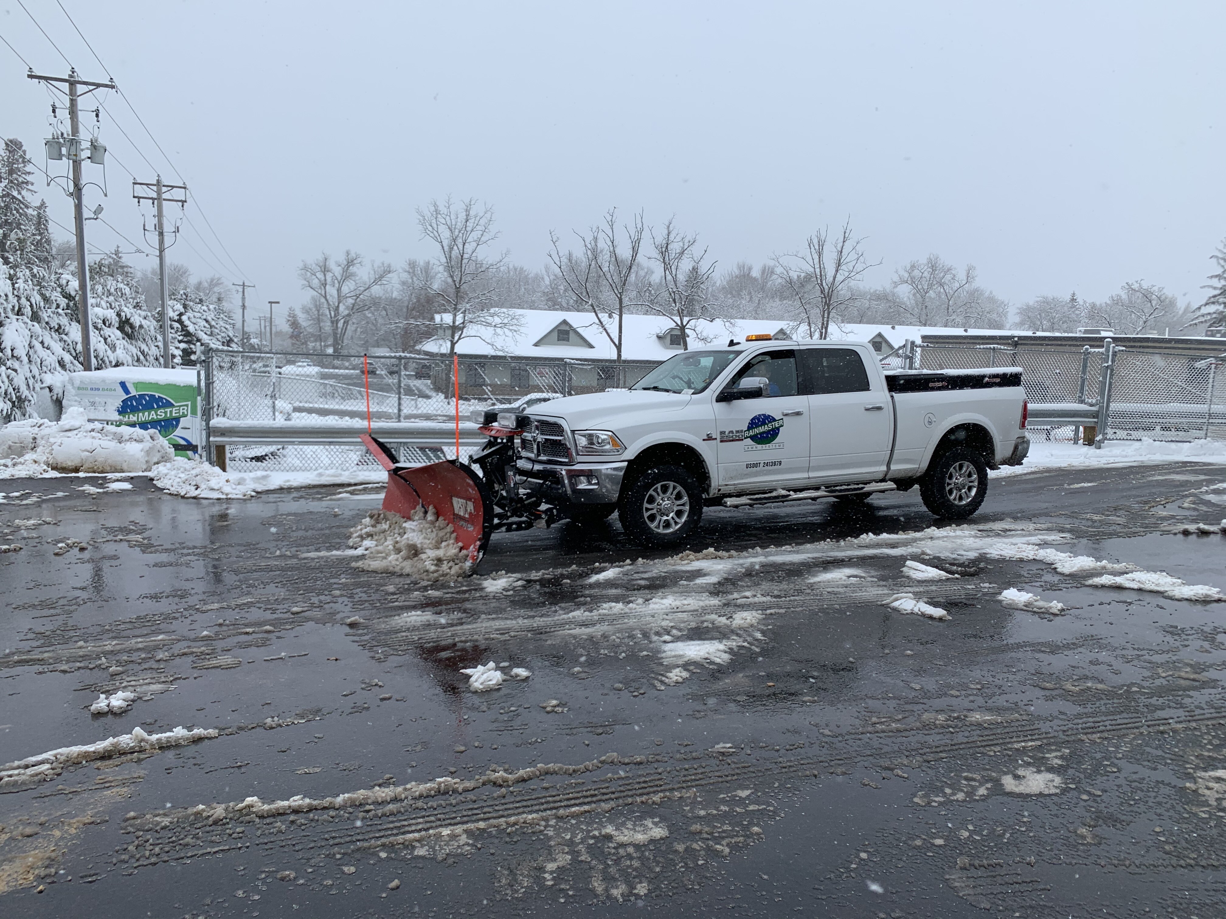 snow removal truck clearing a parking lot in winter