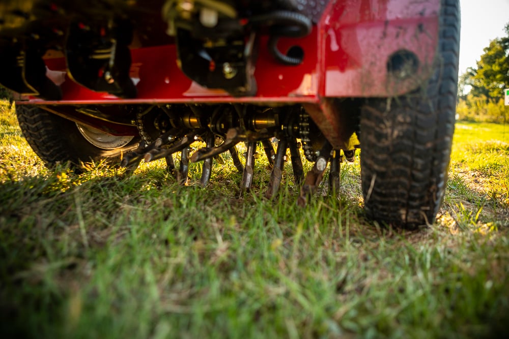 lawn aerator pulling plugs out of a yard