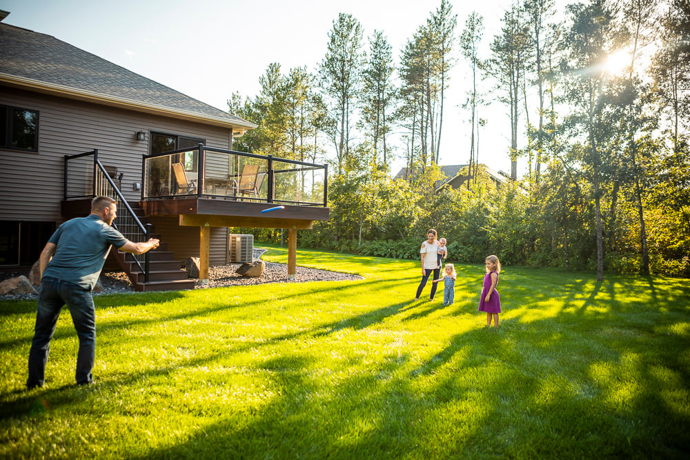 family plays on lush healthy lawn