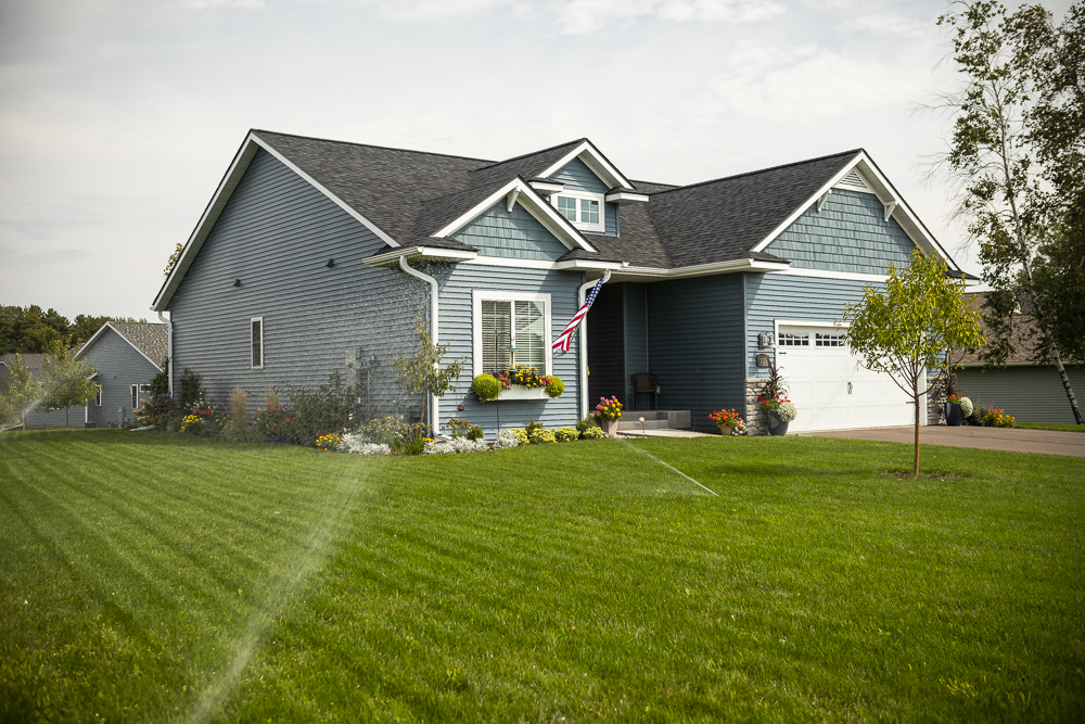 sprinkler system waters lawn in front of home