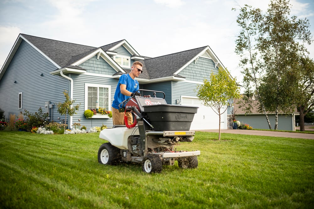 lawn care technician overseeding a minneapolis lawn