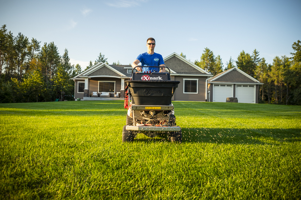 Lawn care team applying granular fertilizer