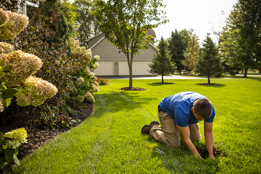 irrigation technician repairs sprinkler system