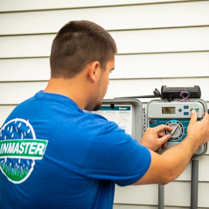 irrigation technician inspecting a system timer