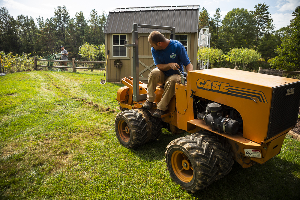 irrigation installation team digs trench for pipe