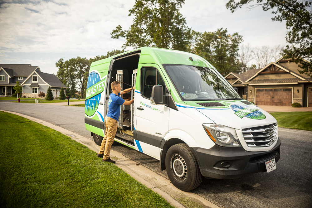 lawn care technician unloading a crew truck at a residential property